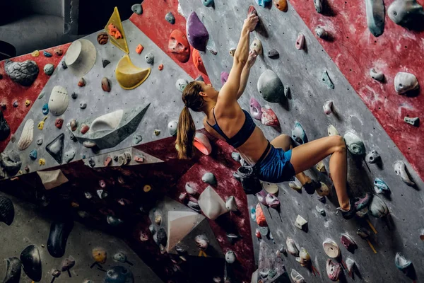 Profi-Bergsteigerin an einer Boulderwand. — Stockfoto