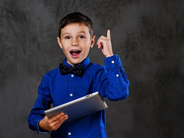 Den positiva tonåring pojken håller tablet Pc. — Stockfoto