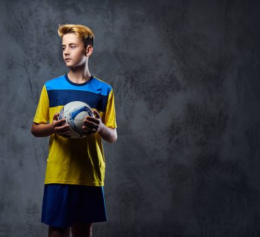 futbol oyuncusu bir topu tutuyor.