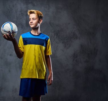 futbol oyuncusu bir topu tutuyor.