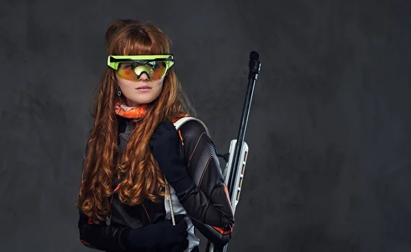 Rotschopf-Biatlon-Weibchen hält Konkurrenzwaffe in der Hand. — Stockfoto