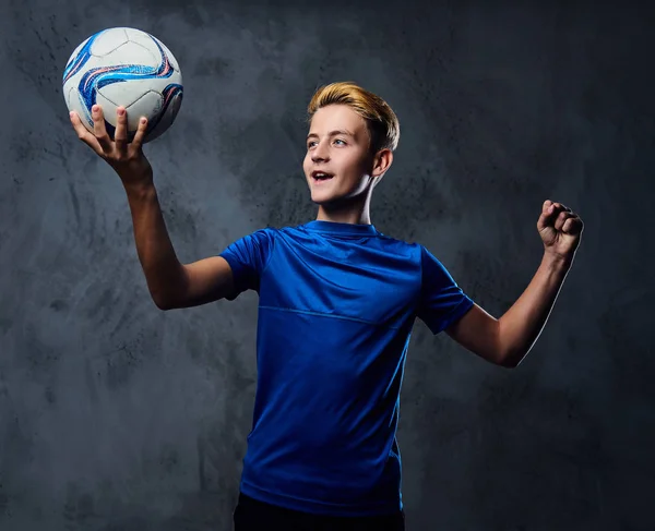 Blond dospívající drží míč. — Stock fotografie