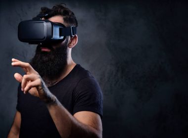 Vr gözlük takan silah dövmeli bir adam.