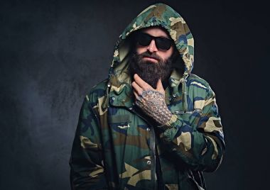 Bir kamuflaj ceket giymiş bir adam 