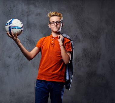 Bir çocuk bir futbol topuyla oynuyor 