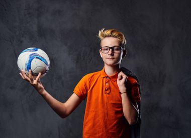 Bir çocuk bir futbol topuyla oynuyor 