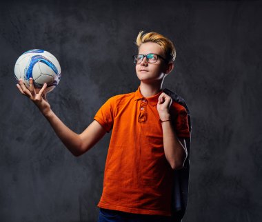 Bir çocuk bir futbol topuyla oynuyor 