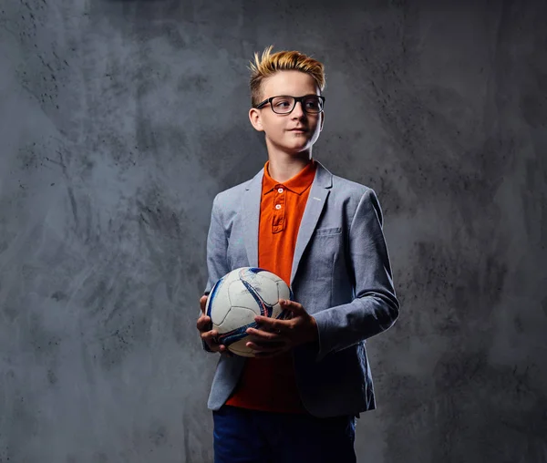 Çocuk bir futbol topu tutuyor 