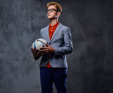 Bir çocuk bir futbol topuyla oynuyor 