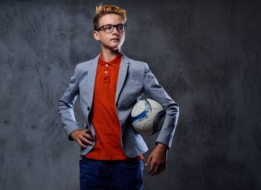 Bir çocuk bir futbol topuyla oynuyor 