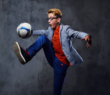 Bir çocuk bir futbol topuyla oynuyor 