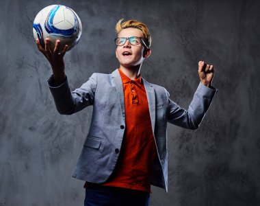 Çocuk bir futbol topu tutuyor 