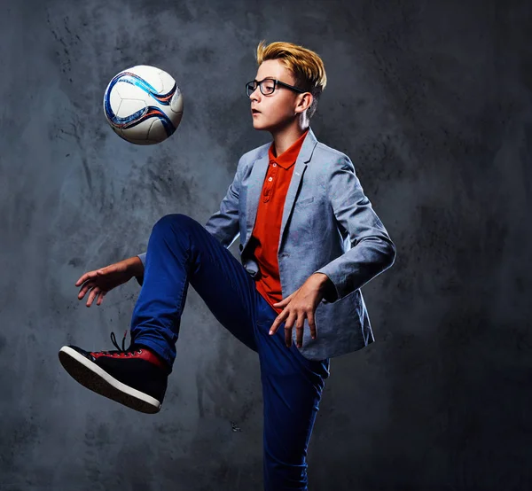 Bir sarışın genç çocuk ile bir futbol topu 