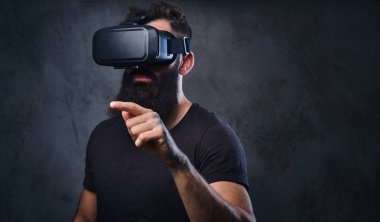 Vr gözlük takan silah dövmeli bir adam.