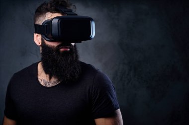 Vr gözlük takan silah dövmeli bir adam.