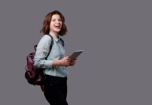 En brunett kvinna håller tablet Pc — Stockfoto