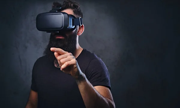 Ein Mann mit Tätowierungen auf den Armen trägt eine Vr-Brille. — Stockfoto