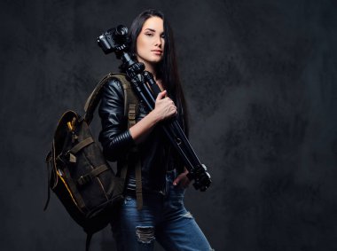 Kadın fotoğrafçı kamera bir tripod üzerinde tutar.