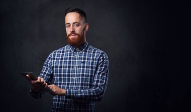 Kızıl saçlı sakallı erkek tablet Pc tutar 