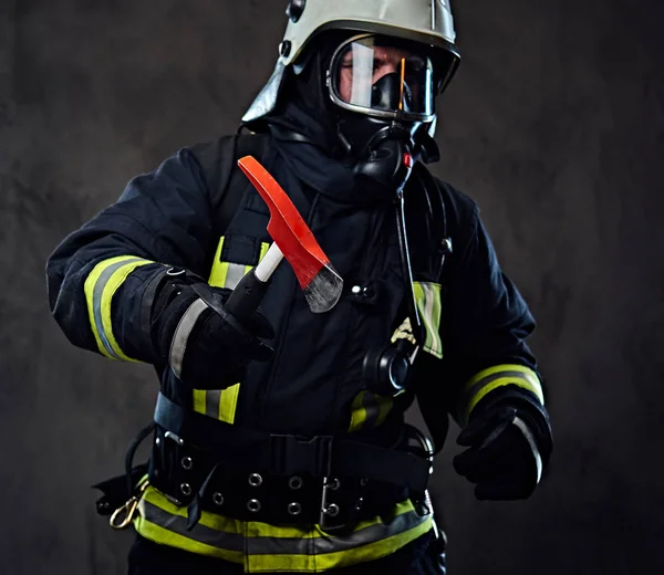 İtfaiyeci üniformalı bir kırmızı balta tutar.