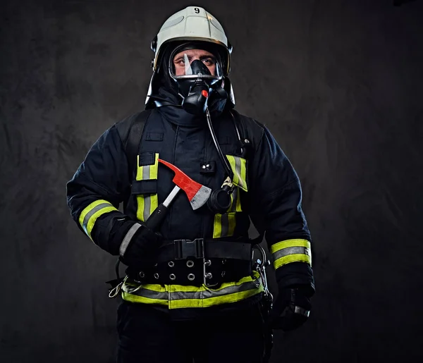 Firefighter in a uniform holds a red axe. — Stock Photo, Image