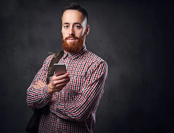 Un hombre con una camisa de lana roja sostiene el teléfono inteligente . —  Fotos de Stock