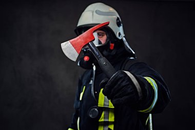 İtfaiyeci üniformalı bir kırmızı balta tutar.