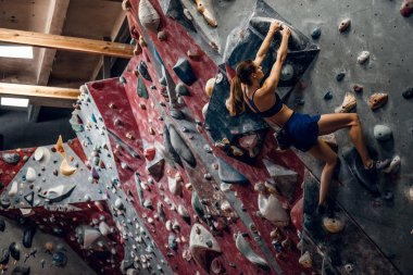 Profesyonel kadın dağcı bouldering duvara.