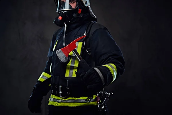Az egységes tűzoltó tart egy piros axe. — Stock Fotó