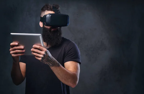 Um homem usando óculos VR e segura tablet PC . — Fotografia de Stock