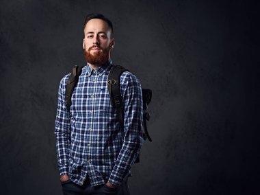 Onun omzunda bir sırt çantası ile bir Polar gömlek giymiş bir adam.