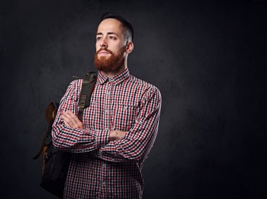 Onun omzunda bir sırt çantası ile bir Polar gömlek giymiş bir adam.