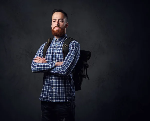 Ein Mann in einem Fleece-Hemd mit einem Rucksack auf der Schulter. — Stockfoto