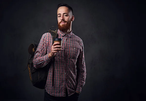 Man houdt een rugzak en koffie kop — Stockfoto