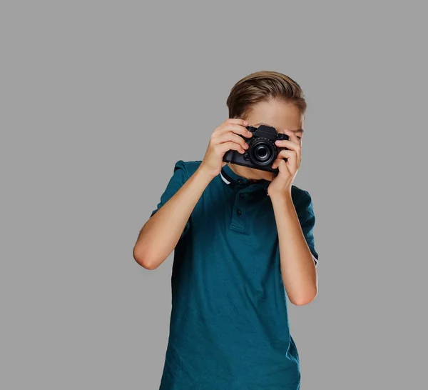 Um menino tirando fotos com uma câmera profissional . — Fotografia de Stock