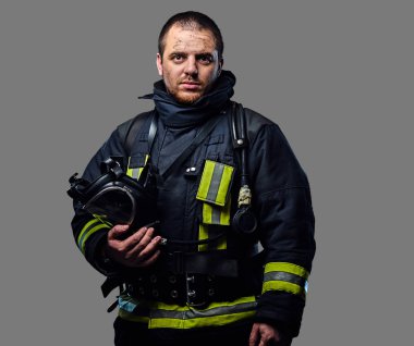 İtfaiyeci Tekdüzen bir oksijen maskesi tutar.