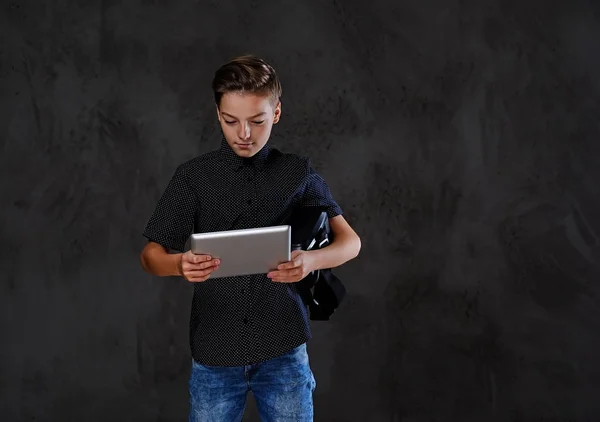 The positive teenager boy holds tablet PC. — Stock Photo, Image