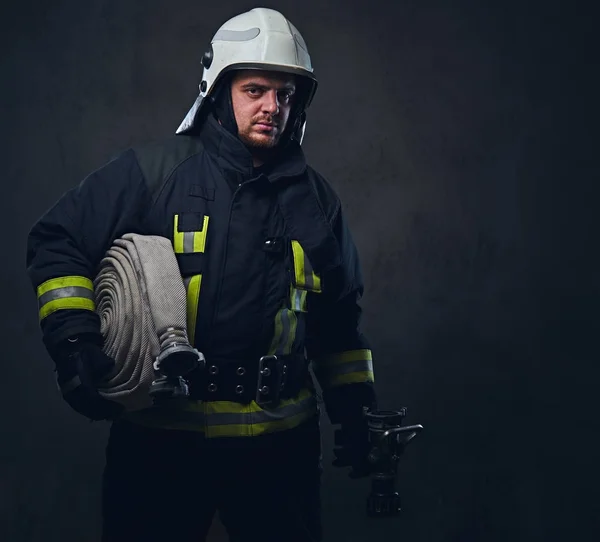 Portrait of a firefighter holds fire hose — Stock Photo, Image