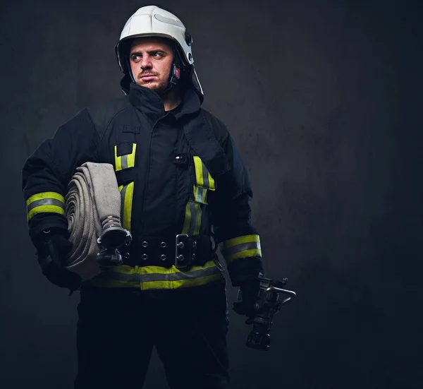 Retrato de un bombero sostiene manguera de fuego — Foto de Stock