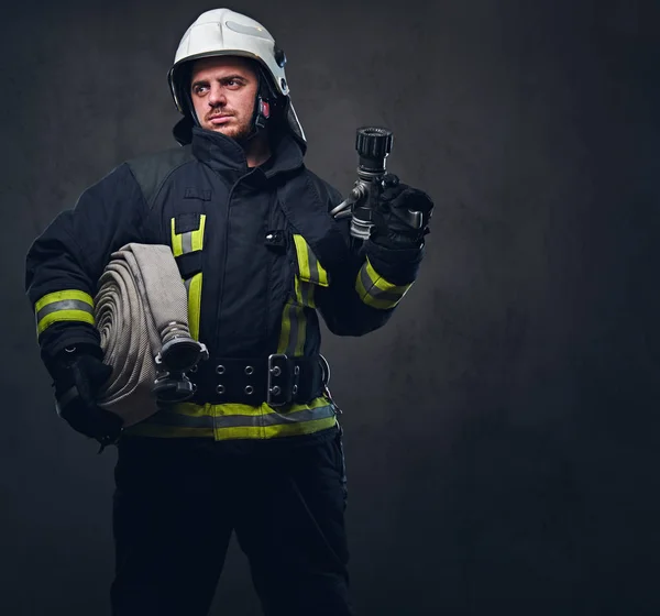 Portrait of a firefighter holds fire hose — Stock Photo, Image