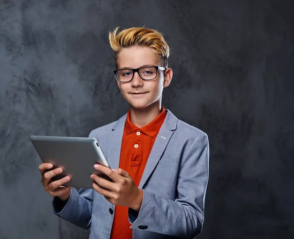 Мальчик в очках держит планшетный компьютер . — стоковое фото