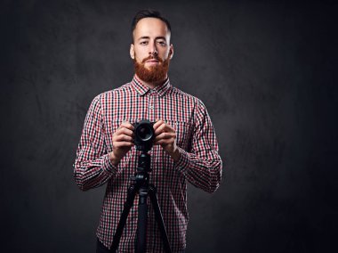 Dijital kamera ve tripod fotoğrafçı tutar