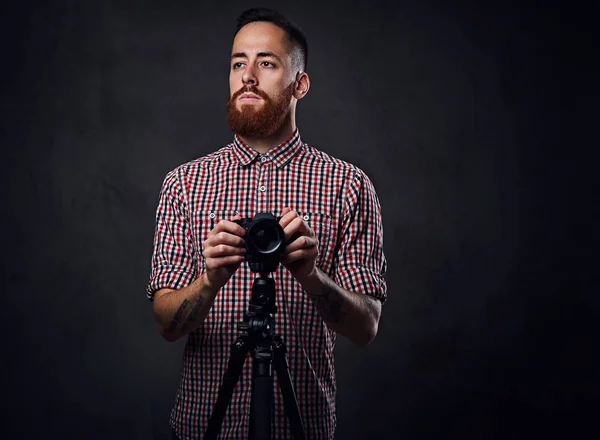 Fotógrafo segura câmera digital e um tripé — Fotografia de Stock