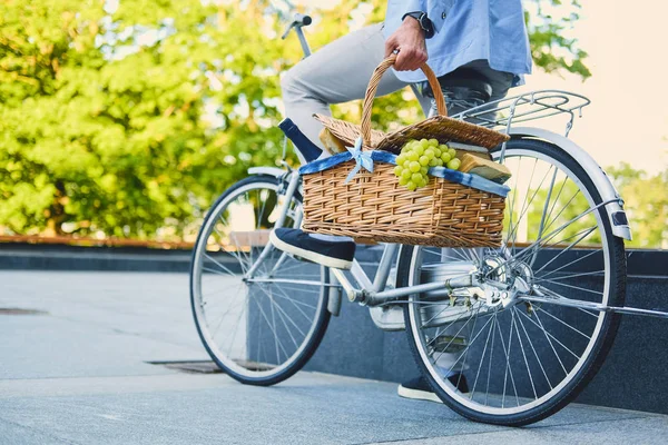 Piknik sepeti adam Bisiklet tutar.