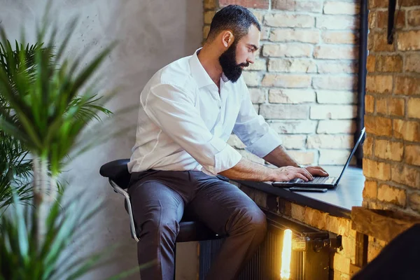 Bir dizüstü bilgisayar ile sakallı erkek 