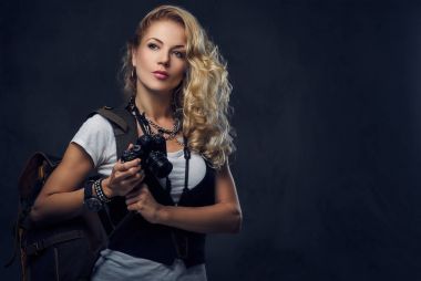 Erkek bir kompakt dijital fotoğraf makinesi tutar.