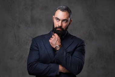 Sakallı adam bir takım elbise giymiş.