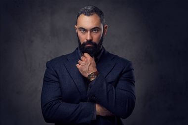 Sakallı adam bir takım elbise giymiş.