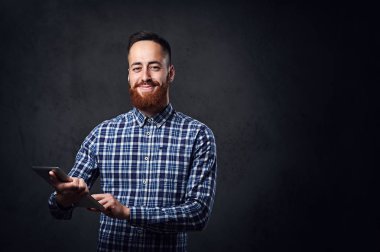 Kızıl saçlı sakallı erkek tablet Pc tutar 