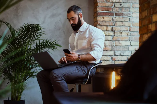 Bir dizüstü bilgisayar kullanarak kentsel sakallı erkek